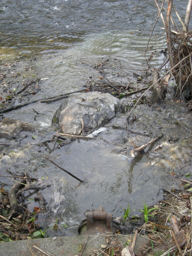 Rejets d'une station d'épuration dans l'Alagnon (remarquez la différence de qualité de l'eau entre le rejet trouble de la station et l'eau limpide de la rivière)